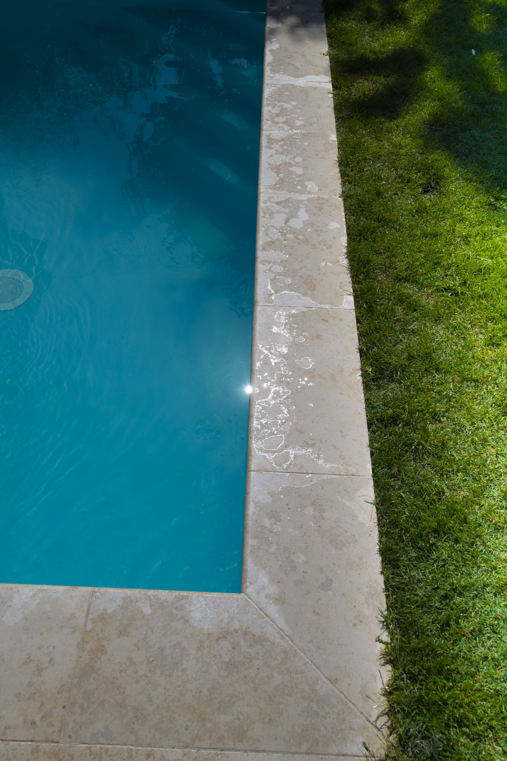 Margelle de piscine en pierre claire bordant la pelouse — Chalon-sur-Saône, Saône-et-Loire — Perret Paysage & Piscine