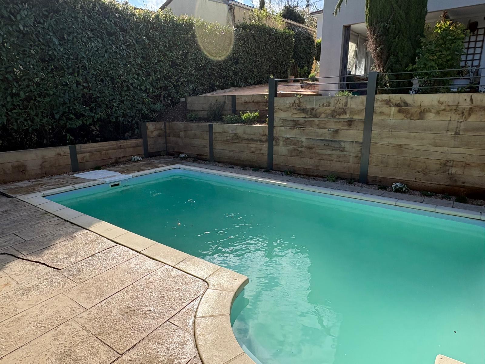 (Chantal P. — Mâcon) : Piscine et terrasse bordées d'une palissade en bois — Mâcon, Saône-et-Loire — Perret Paysage & Piscine