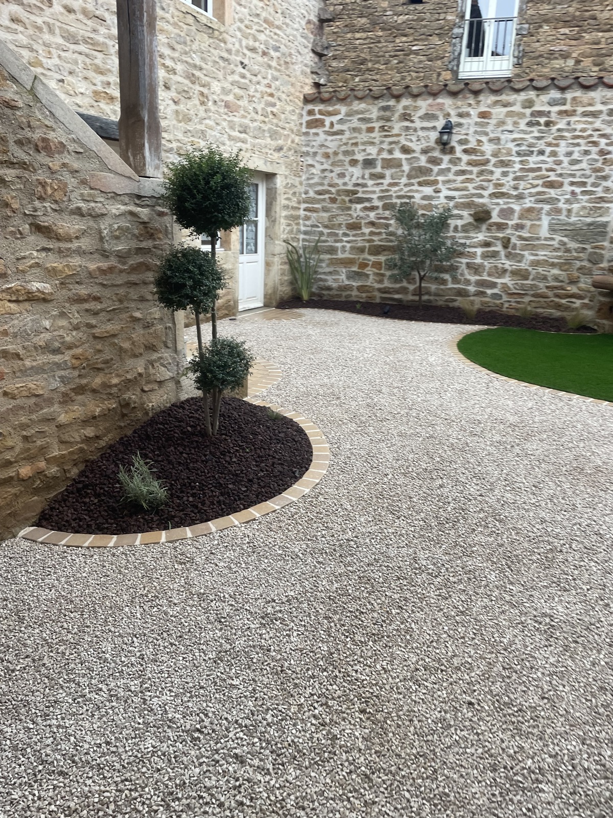 Cour en gravier stabilisé avec buis taillés en topiaire et gazon synthétique — Mâcon, Saône-et-Loire — Perret Paysage & Piscine