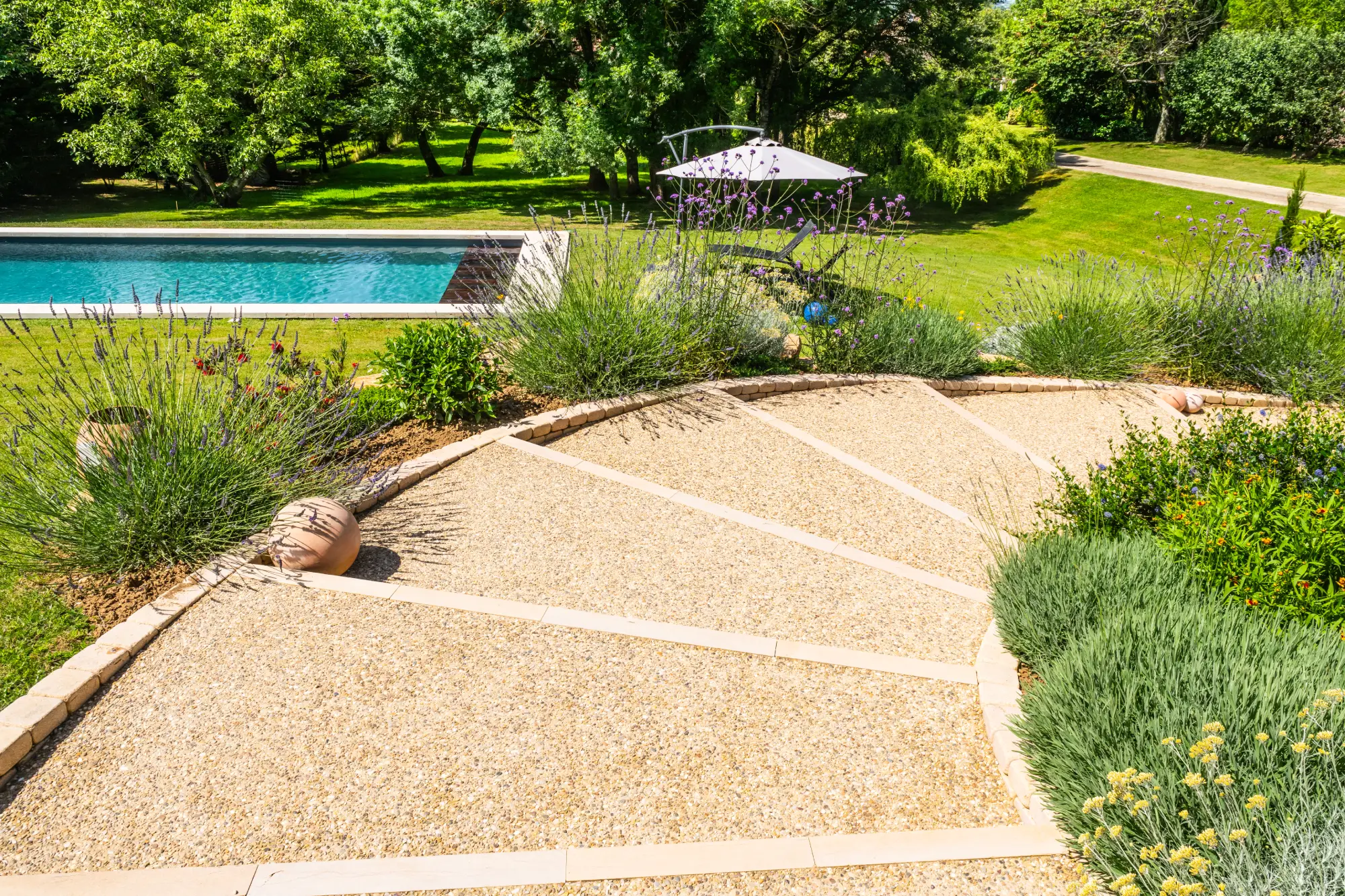 Terrasse en gravier stabilisé avec massif de lavandes et piscine en arrière-plan — Beaune, Côte-d’Or — Perret Paysage & Piscine