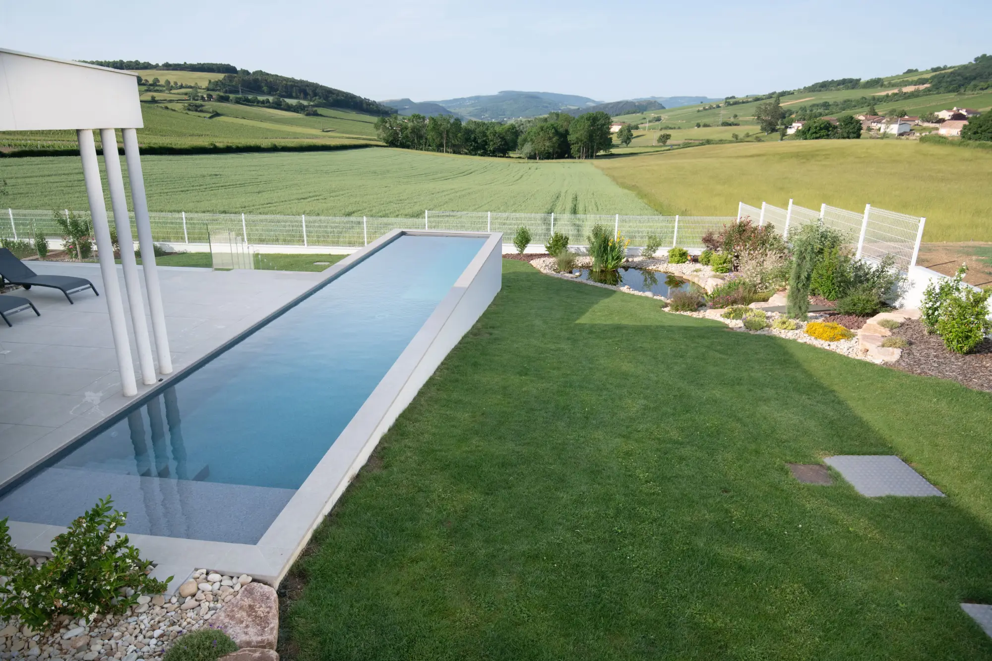 Piscine à débordement avec terrasse surplombant le vignoble mâconnais — Mâcon, Saône-et-Loire — Perret Paysage & Piscine