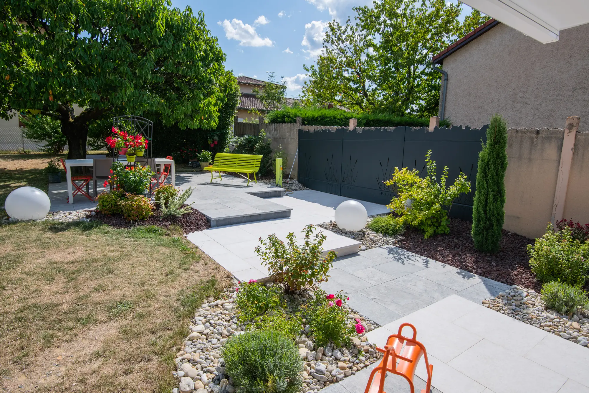 (Daniel B. — Charnay-lès-Mâcon) : Jardin aménagé avec terrasse et mobilier coloré — Charnay-lès-Mâcon, Saône-et-Loire — Perret Paysage & Piscine