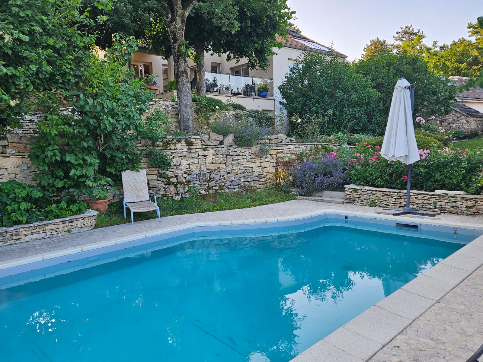 (Vincent M. - Beaune) : Piscine enterrée et terrasse en pierre dans un jardin aménagé en paliers — Beaune, Côte-d’Or — Perret Paysage & Piscine